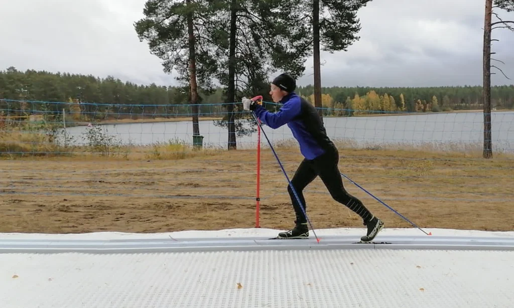 Kuva ns. älyladusta, jolla hiihtäjä on hiihtämässä. Kuva otettu ulkona kesäaikana. Taustalla näkyy järveä ja metsää.