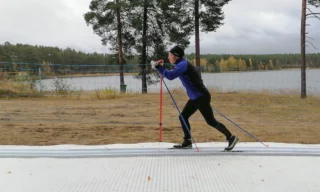 Kuva ns. älyladusta, jolla hiihtäjä on hiihtämässä. Kuva otettu ulkona kesäaikana. Taustalla näkyy järveä ja metsää.