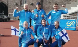 Rinkilajien eli moukarinheiton, kuulantyönnön ja kiekonheiton urheilijoita yhteiskuvassa. Heillä on päällään Suomen yleisurheilumaajoukkueen vaatteet ja muutamalla myös Suomen lippu kädessään.