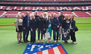 Joukko suomalaisia yritysdelegaation edustajia seisoo ryhmäkuvassa Real Madridin kotistadionilla.