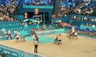 Parakoripallon pelaajia pelissä Pariisin 2024 paralympialaisissa. Katsomo täynnä yleisöä.